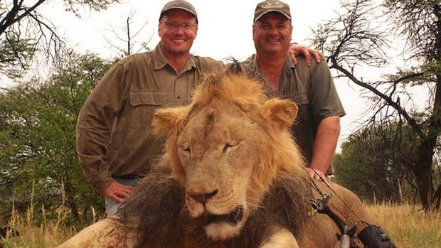 Walter Palmer, left,  poses with the body of Cecil the lion and an unidentified man, after hunting and wounding him with his bow, and shooting him 40 hours later.