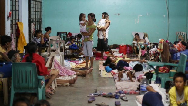 Filipino families seek refuge at a school used as an evacuation centre.