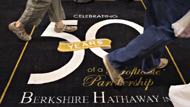 Shareholders walk on a 50th anniversary commemorative carpet during the Berkshire Hathaway shareholders meeting.