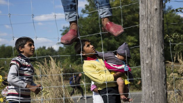 Children run from a collection point set up to transport refugees to camps in Morahalom, Hungary. 