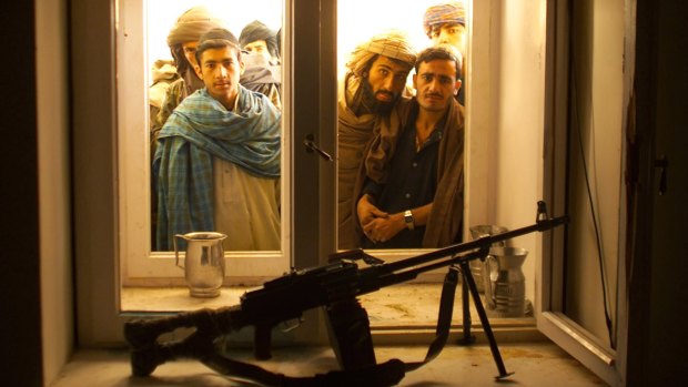 Afghans look through the window into the bedroom of Taliban leader Mullah Omar  after his overthrow in December 2001. 