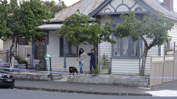 A dog is removed from the house where a man was shot dead in Brunswck.