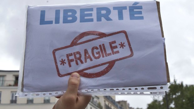 A demonstrator holds a paper which reads, "liberty, fragile", during a protest against the state of emergency in Paris in September.