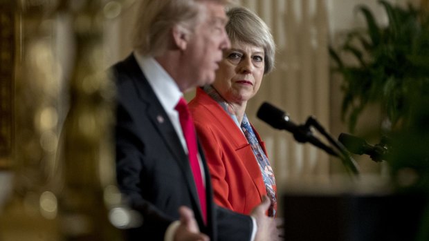 Theresa May listens as Donald Trump speaks during a joint news conference.