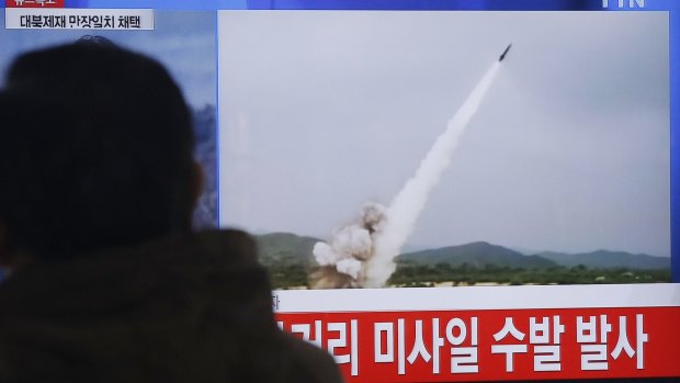 A man watches a news bulletin showing footage of a missile launch conducted by North Korea.
