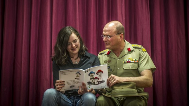 Teen author Jessica Love and her father, Australian Army Colonel Shaun Love, look at her book addressing parental deployment through a child's eyes.