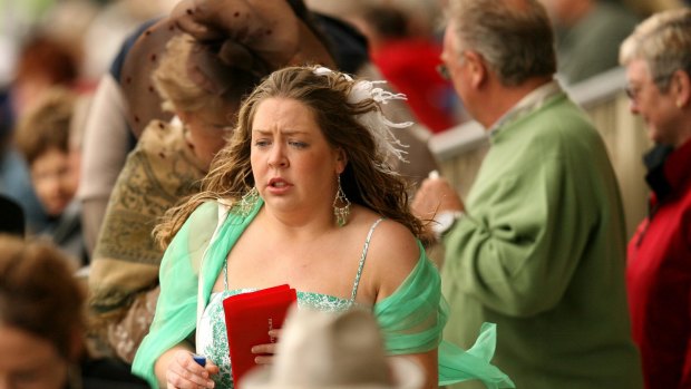 A racegoer shivers through Melbourne Cup day in 2006.