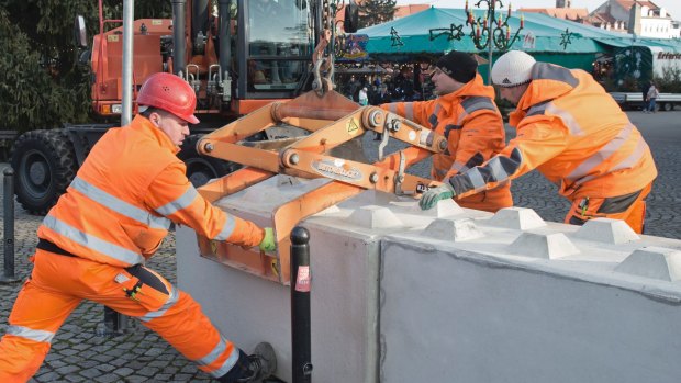 Workers set concrete barriers at the Christmas market in Erfurt, central Germany.