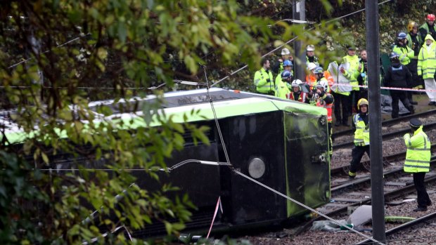 Emergency service workers attend the scene of the derailed tram in Croydon, south London.