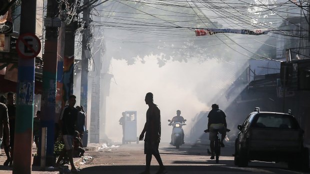 Garbage fire smoke lingers during an ongoing police operation.