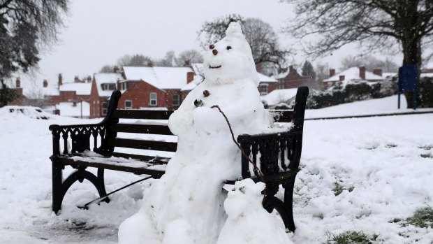 A snowman and dog on a bench in Worcester, England.