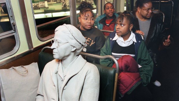 Visitors sit behind the figure of Rosa Parks, seated in the front of a bus at the National Civil Rights Museum in Memphis.
