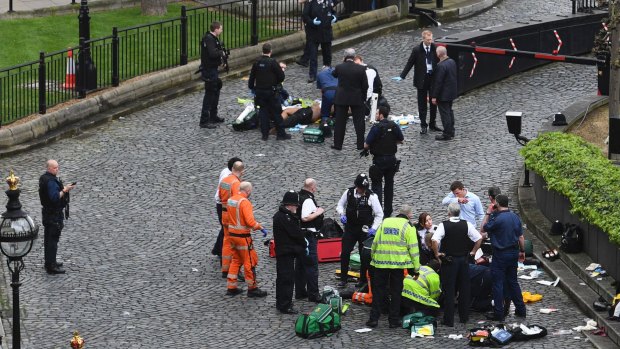 Emergency services attend to injured people outside the Palace of Westminster, London, 