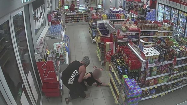An image from CCTV footage of the man dragging his girlfriend out of the service station.
