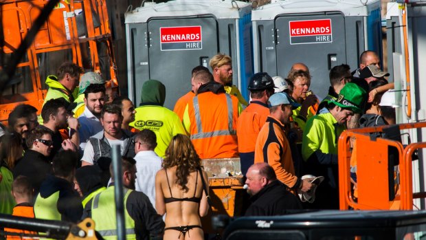 Strippers hand out drinks and mingle with construction workers at the Geocon Wayfarer apartment building in Belconnen.