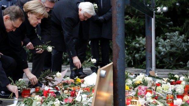 German Chancellor Angela Merkel and Foreign Minister Frank-Walter Steinmeier, right, lay flowers at the scene of the terror attack in Berlin.