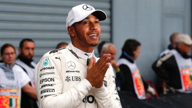 Hands together: Lewis Hamilton revels after claiming his 69th career pole position to break Michael Schumacher's Formula One record.
