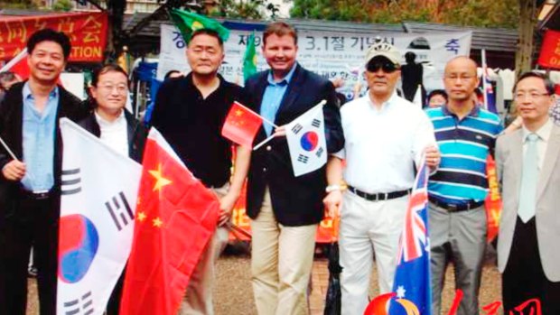 Craig Laundy (holding Chinese and Korean flags) and Yang Dongdong (far right) at a protest against Shinzo Abe's visit to the Yasukuni Shrine.

