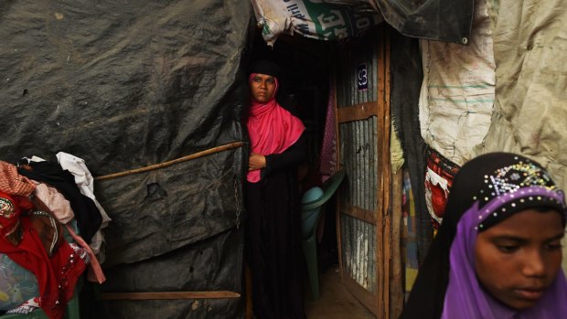 Mother and her daughter, at right, at the entrance to a temporary shelter inside a camp for Rohingya families that fled the violence in Myanmar