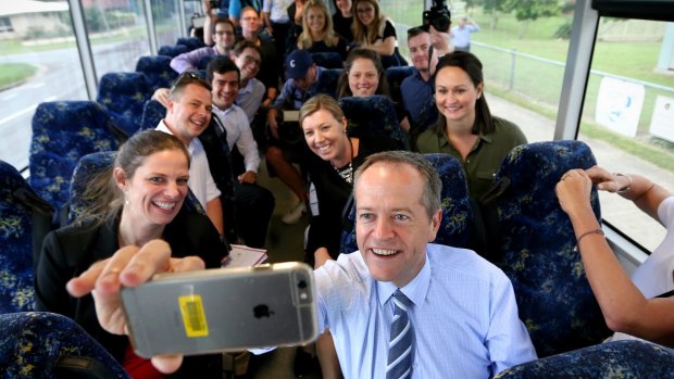 Opposition Leader Bill Shorten takes a selfie with media on the campaign bus on the way to Beaconsfield State School in Mackay, Queensland.