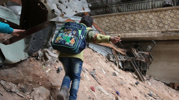 A child navigates through rubble and barbed wire in Aleppo this week.