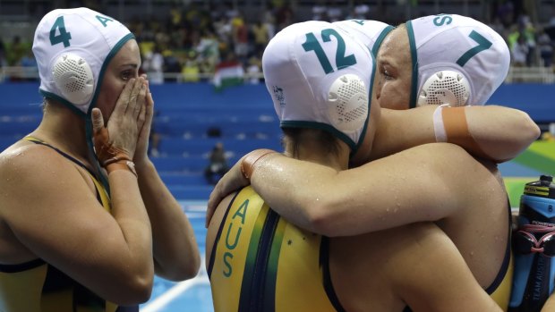 Heartache: Australia's players console each other after losing in a penalty shootout.