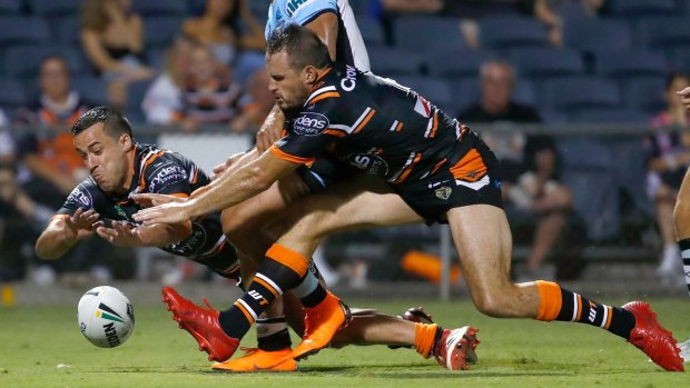 New Faces: Corey Thompson and Josh Reynolds of the Tigers dive to score a try during a pre-season match with the Cronulla Sharks.