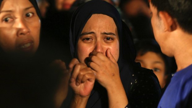 Relatives cry during a mass funeral for victims of the school fire outside of Kuala Lumpur.