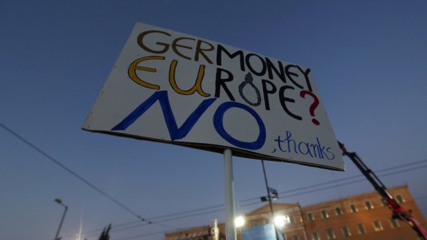 Supporters of Alexis Tsipras, Greece's prime minister, wave banners during a "No" rally against accepting bailout conditions. Greece's finance minister has accused creditors of financial 'terrorism'. 