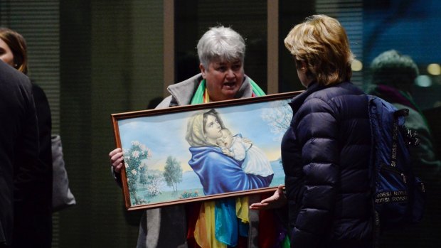 Julie Cameron holds a painting of the Virgin Mary and child outside the Melbourne Magistrates Cout.