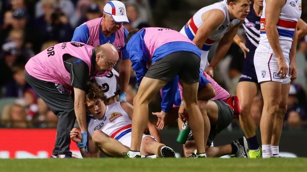 Bulldog Liam Picken is assisted off the field after suffering a concussion during the round three  match against Fremantle.