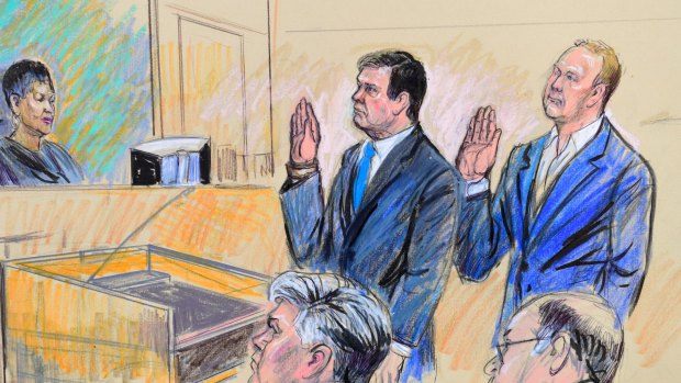 A court artist drawing shows President Donald Trump's former campaign chairman, Paul Manafort, center standing and Manafort's business associate, Rick Gates, in federal court in Washington.