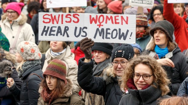 Protesters hold placards with slogans, during the Women's March rally, in Geneva, Switzerland.