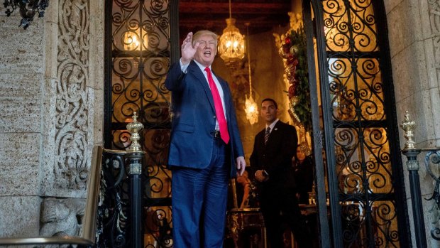 Donald Trump waves to members of the media after a meeting with admirals and generals from the Pentagon at Mar-a-Lago in December.