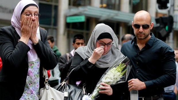Members of the Muslim community lay flowers at Martin Place after two people and a gunman died when the siege ended Tuesday morning. 