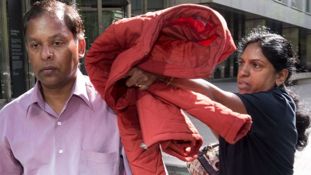 Kandasamy and Kumuthini Kannan  try to conceal their faces as they leave court in February.