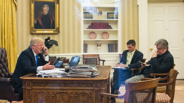 Happier times: Trump takes a call with former national security advisor Michael Flynn and Stephen Bannon in attendance, in the Oval Office.