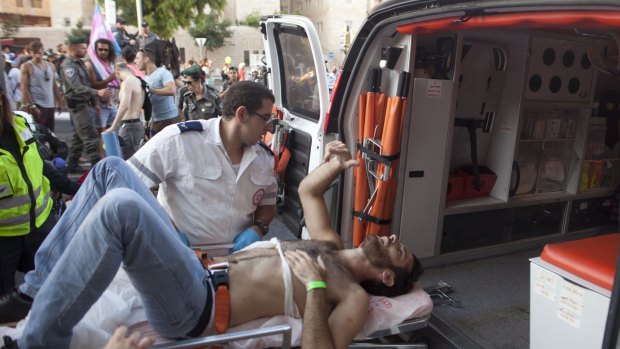A wounded Israeli man receives treatment after the attack at Jerusalem's Gay Pride parade. 