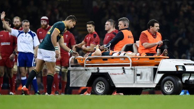 Tough luck: Springboks captain Jean de Villiers is taken from the ground with a knee injury during his side's loss to Wales in Cardiff.