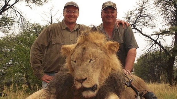 Walter Palmer (left) poses with the corpse of Cecil the lion after hunting him with his bow, wounding the leader of the pride, and shooting him 40 hours later.