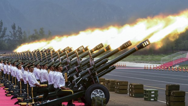 Paramilitary policemen and gun salute team members fire cannons at an unrelated event in Beijing.