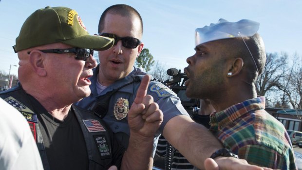 A police officer tries to separate angry citizens in Ferguson in March, as anger intensified following the shooting death of Michael Brown. 