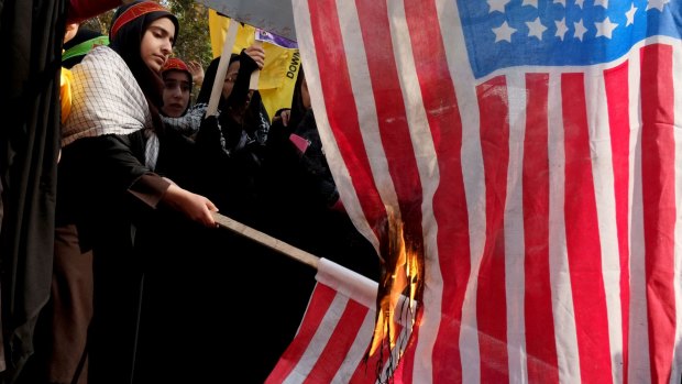 Burning the US flag to mark the 34th anniversary of the 1979 US embassy takeover in Tehran in 2013. 