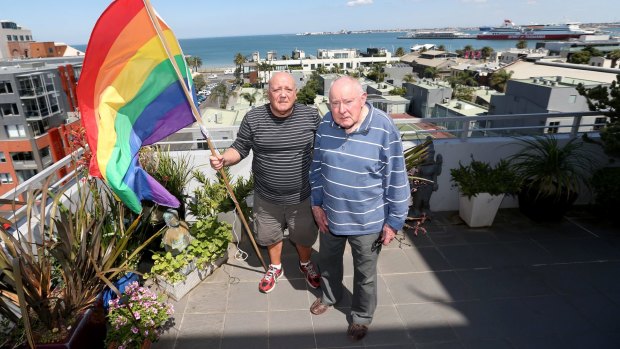 James Bellia and Murray Sheldrick on the balcony of their Port Melbourne apartment, after being told to stop flying their flag.