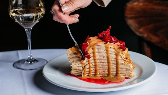 Crepe cake with dulce de leche cream and rosella flowers.