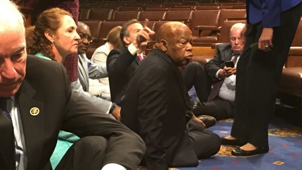 Democrat members of Congress, including Representatives John Lewis, centre, participate in sit-down protest.
