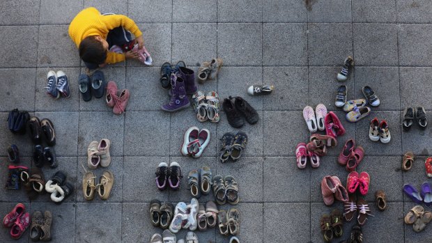 A young migrant boy tries on shoes donated by the people of Hungary at Keleti station.