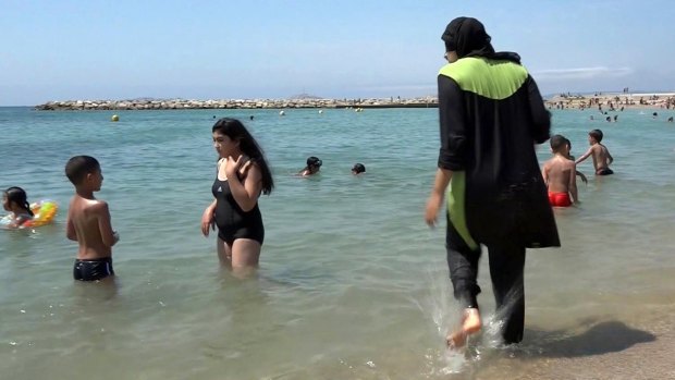 Nissrine Samali, 20, gets into the sea wearing a burkini in Marseille, southern France. 