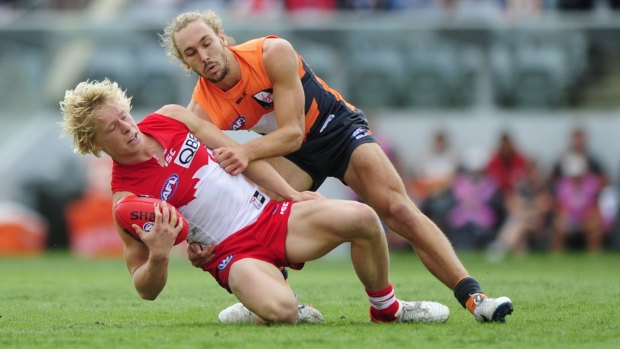Sydney Swans player Isaac Heeney  is tackled by Greater Western Sydney Giants player Matt Buntine. 