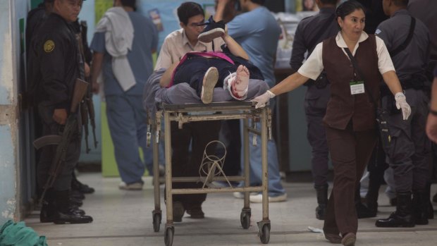 Nurses transport Astrid Villatoro who was wounded by a stray bullet during an assault staged by unknown attackers at the Roosevelt Hospital, in Guatemala City.